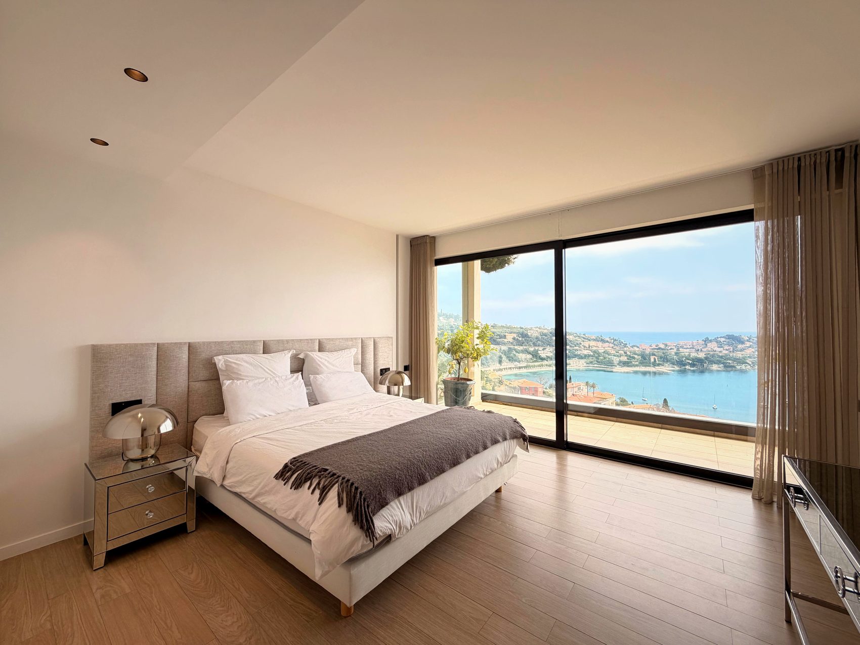 Chambre principale avec baie vitrée cadrant la mer