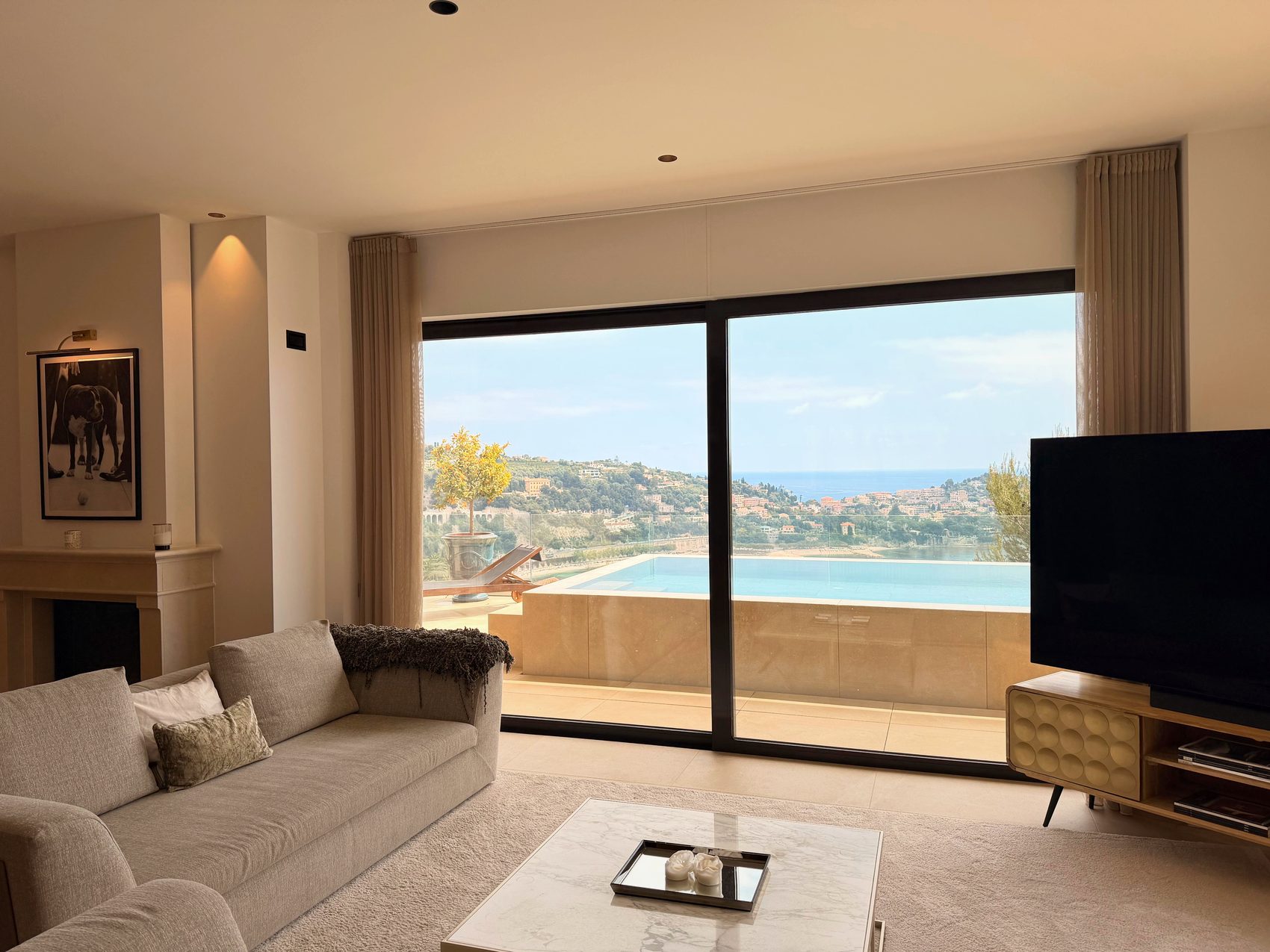 Salon au coin du feu avec vue mer à travers de grandes baies